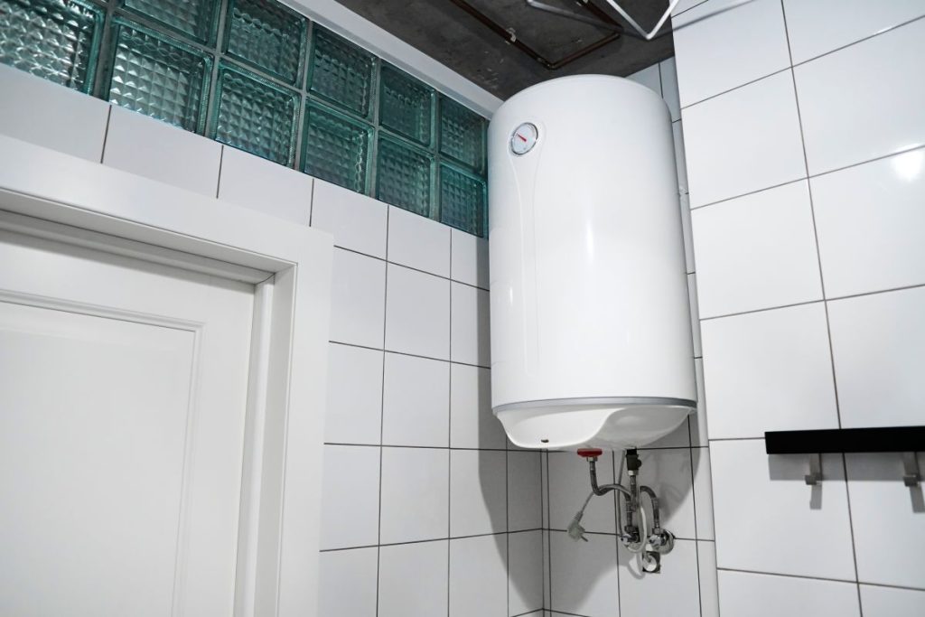 Modern gas tanked boiler in bathroom. Household budget water heater hanging on the wall in boiler room